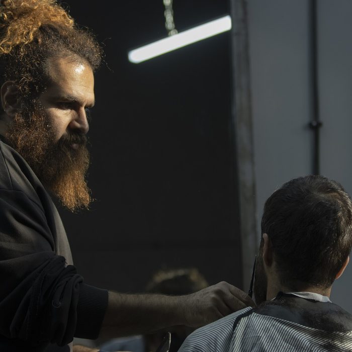 حلاق بلحية كثيفة يقص بالمقص